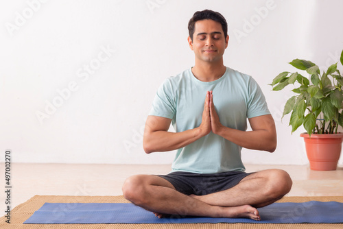 Portrait of a young man meditating at home