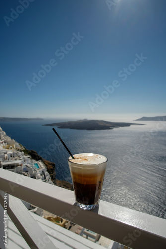 An iced coffee, also known as Freddo Cappuccino, overlooking the aegean sea and the famous village of Fira Santorini