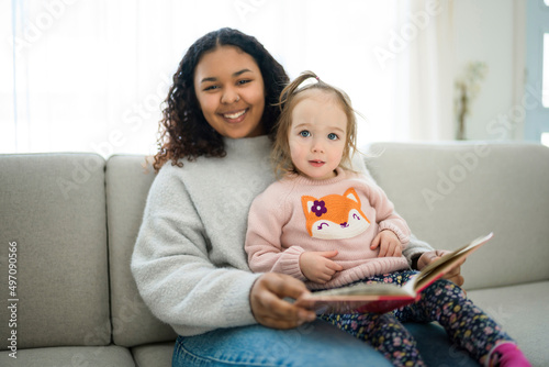 babysitter black woman read book with little child girl