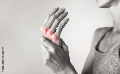 Woman suffering from pain in hands and fingers, arthritis inflammation. Red highlight