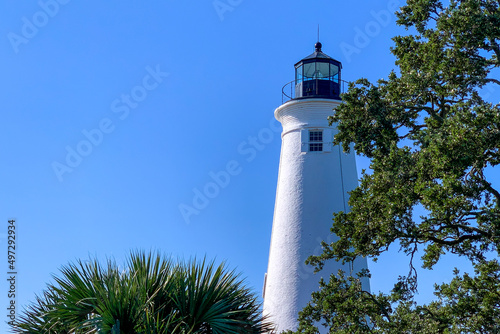 Historic coastal lighthouse with foreground trees