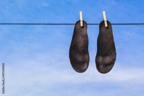 Black insoles drying on laundry or clothes line