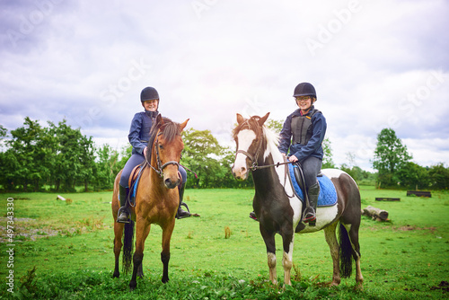 Saddle up, its time to ride. Shot of two teenage girls going horseback riding on a ranch.