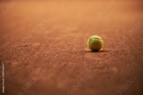 green tennis ball on a brown tennis court background. Yellow tennis ball on a clay court. Light green tennis ball on a clay court, space for text.