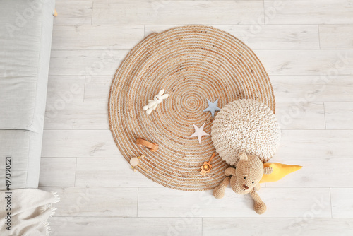 Wicker carpet with pouf and toys in children's room