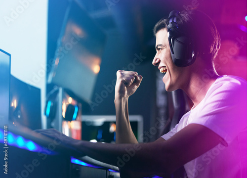 Lifes a game so level up. Shot of a young man cheering while playing computer games.