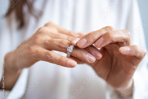 Close up of decisive woman take off wedding ring make decision breaking up with husband, young female remove engagement jewelry having relationships problems filing for divorce or annulment