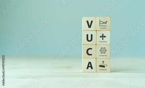 VUCA and strategic management. Wooden cubes with VUCA icon and text; volatility, uncertainty, complexity, ambiguity with grey background. Smart management for new trend and rapid transition.