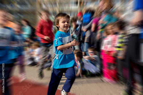 Young preschool children, running on track in a marathon competition, radial blur motion