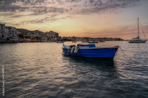 Typical fishing boat moored at Ischia Ponte port at sunset, Ischia, Italy