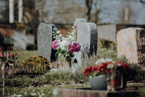 grave stone with flowers at graveyard