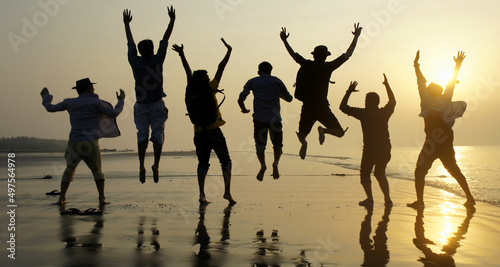 Big group of seven happy friends is having fun and jumping on beach during sunset time at Kuakata sea beach, Bangladesh