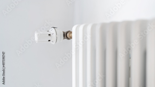 Regulator knob on white heating radiator in room
