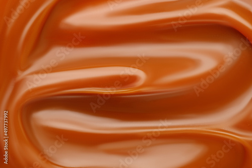 Liquid caramel syrup. Background of caramel paste. Texture Close up, top view.