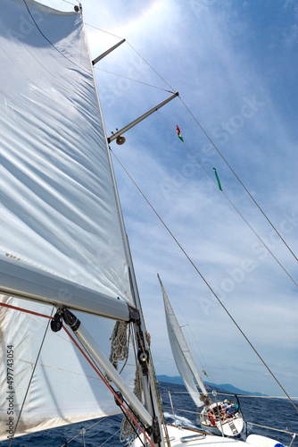 Dettaglio di vele su sfondo cielo azzurro durante una regata in mare