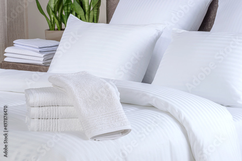 Clean white bath towels on the neatly clean bed of hotel room - coziness and clean concept