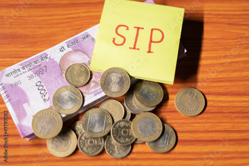 Sip with coin and stack of money table - concept of savings , investment, financial and wealth creation.