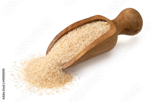 Raw psyllium husk in the wooden scoop, isolated on white background.