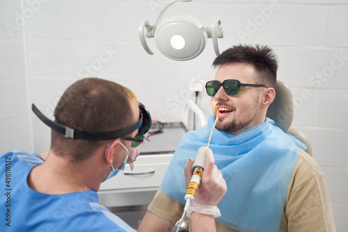 Smiling man being treated in otorhinolaryngologist office