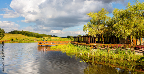 Panoramic view of Jezioro Wegleszynskie lake with wooded shores and and wooden jetty platform in Ostrzyce village in Kashubia region of Poland