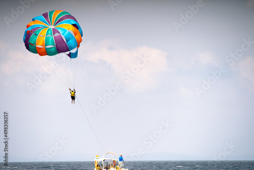 multiple boats in distance doing para gliding sailing while adventure sports like jet sking happening showing busy summer season in goa havelock andaman nicobar island india