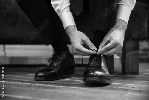groom putting on wedding shoes 