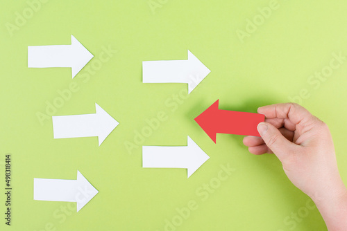 White arrows on a green background, one is standing out, do different, be a winner, individuality, making your own decision, leadership, target new idea 