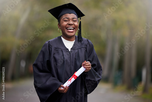 Your girl just got qualified. Portrait of a young woman holding her diploma on graduation day.