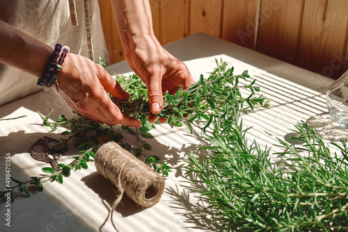 Alternative medicine. Woman holding in her hands a bunch of marjoram. Herbalist woman preparing fresh scented organic herbs for natural herbal methods of treatment.