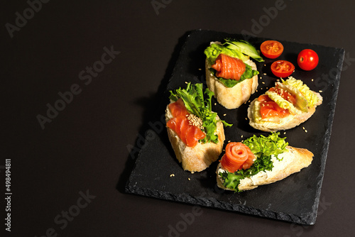 Assorted open sandwiches with salted salmon, cream cheese, salad leaves and cucumber. Seafood