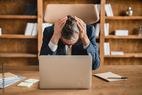 Tired exhausted depressed overworked businessman ceo boss freelancer having working problems issues deadline headache migraine, being fired in office working on laptop
