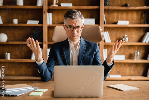 Angry sad caucasian mature middle-aged businessman boss employee freelancer ceo making mistake error, being fired, deadline at work on laptop. Job problems