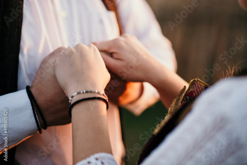 Closeup of couple's hands in Serbian traditional costume
