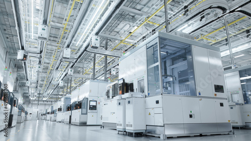 Wide shot of Bright Advanced Semiconductor Production Fab Cleanroom with Working Overhead Wafer Transfer System 