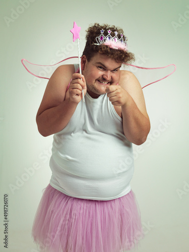 Toothfairy with a twist. An overweight man with a naughty expression wearing a pink fairy costume.