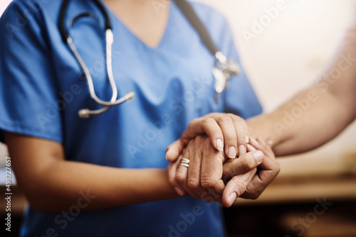 You dont have to face your challenges alone. Cropped shot of an unrecognizable female nurse holding a senior womans hands in comfort.