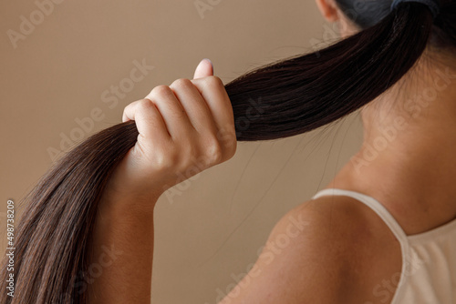 Young woman hand holding ponytail in studio