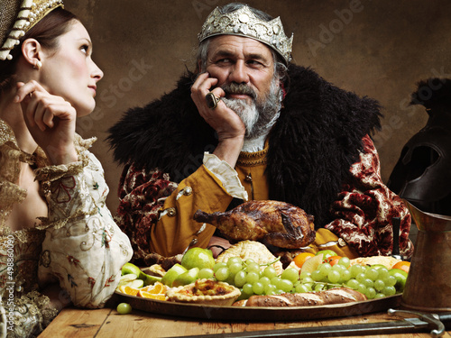 Royal life can be tedious.... A bored queen sitting alongside her husband at a banquet.