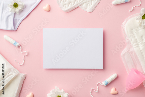 Top view photo of paper sheet camomile flower buds small hearts lingerie menstrual cup sanitary napkins and tampons on isolated pastel pink background with copyspace