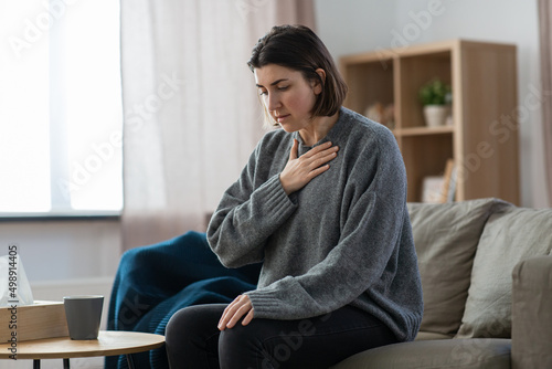 mental health, psychological problem and depression concept - sad woman having trouble breathing or panic attack at home