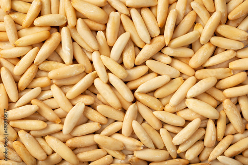 Food background of roasted European pine nuts, top view.