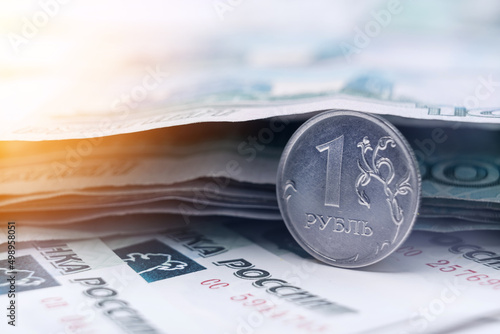 Russian ruble coin on the background of paper banknotes of 1000 rubles.