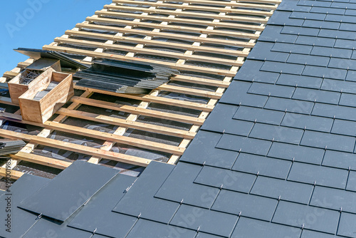 Image of a construction site covering a slate roof of a house.