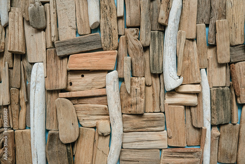 driftwood wall.Gray and brown sea driftwood texture.driftwood background.Natural wood decor in a nautical style.row of sea snags on blue background. Flat lay, top view.