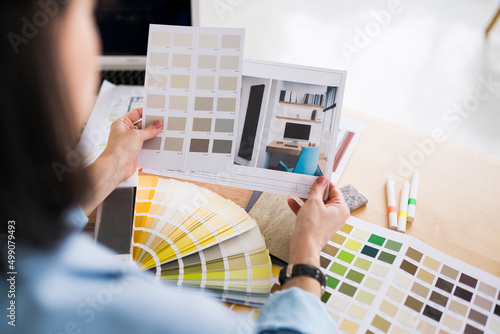 Close up of woman architect working on interior renovation. Designer choosing color samples according to the visualization of the project. Architecture and interior design concept.