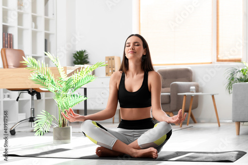 Young barefoot woman meditating at home