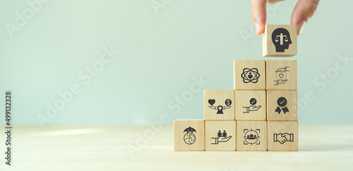 Business ethics concept. Ethics inside human mind. Business integrity and moral. Putting wooden cubes with ethics inside a head standing with other ethics icon. Company culture and sustainable success