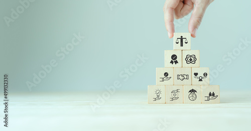 Business ethics concept. Ethical mindset. Business integrity and moral. Putting wooden cubes with ethics icon standing with other ethics icon. Company culture and sustainable success