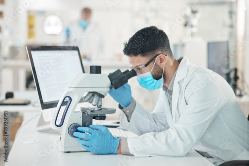 You have to look at it from different perspectives. Shot of a young scientist using a microscope in a lab.