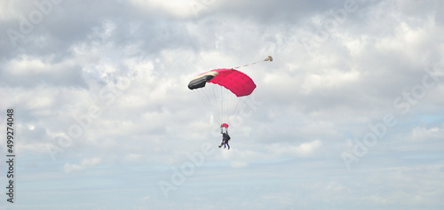 Duas pessoas a saltar de paraquedas, skydive, desporto radical, com o céu enublado - desporto radical